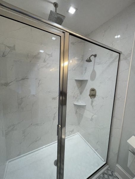 a bathroom with a shower with a glass door