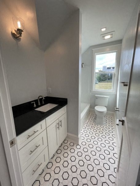 a bathroom with a toilet and a sink and a window