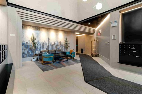 the lobby of the building is spacious and has a large screen tv