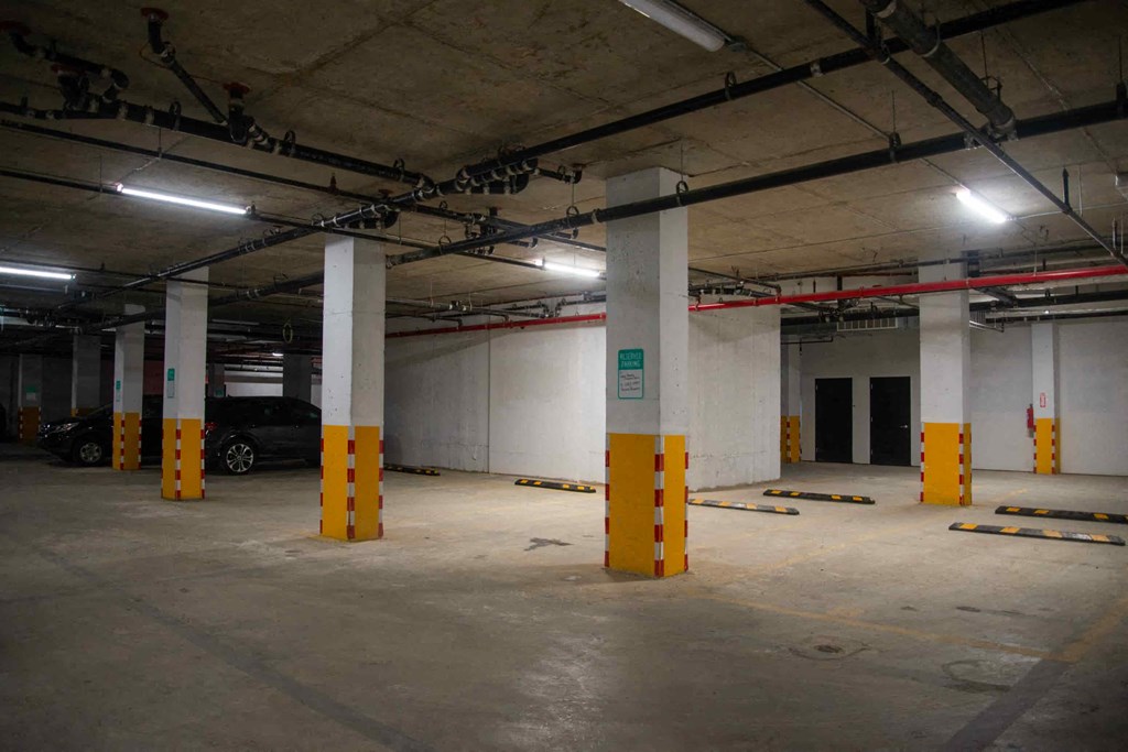 a parking garage with pillars and a car parked in it