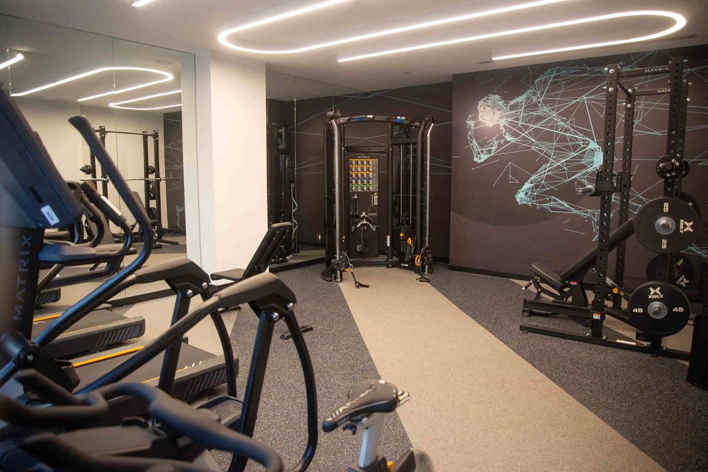 a gym with exercise equipment and a wall mural of a soccer player