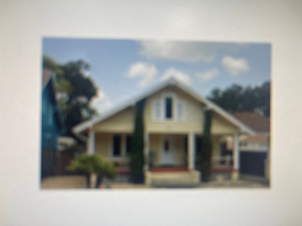 a picture of a yellow house with a blue sky in the background