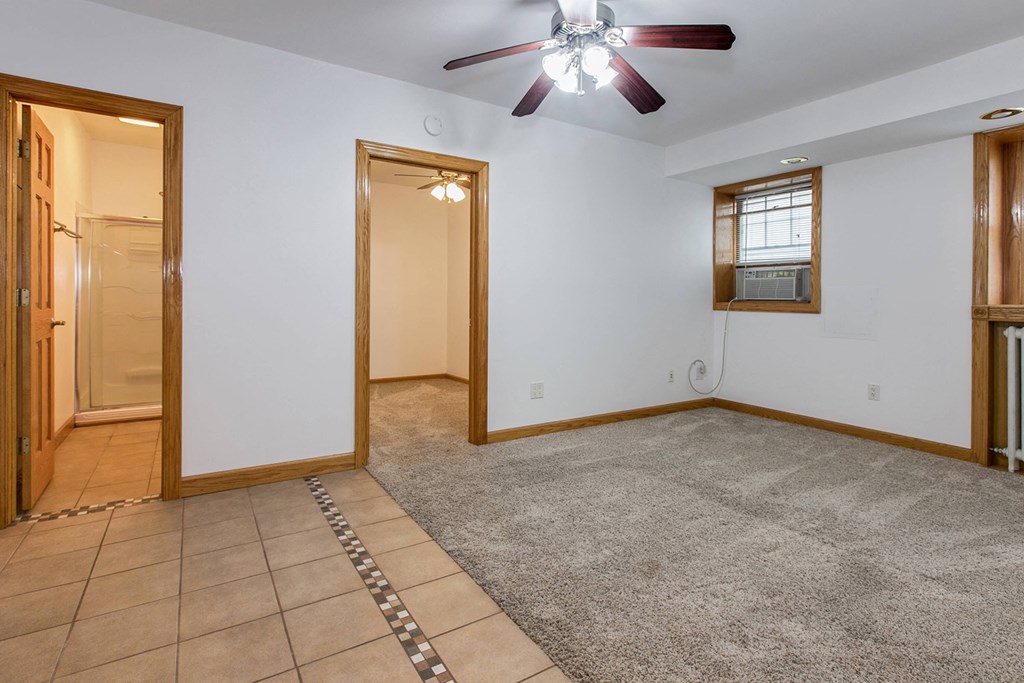 the living room and entryway of a house with a ceiling fan