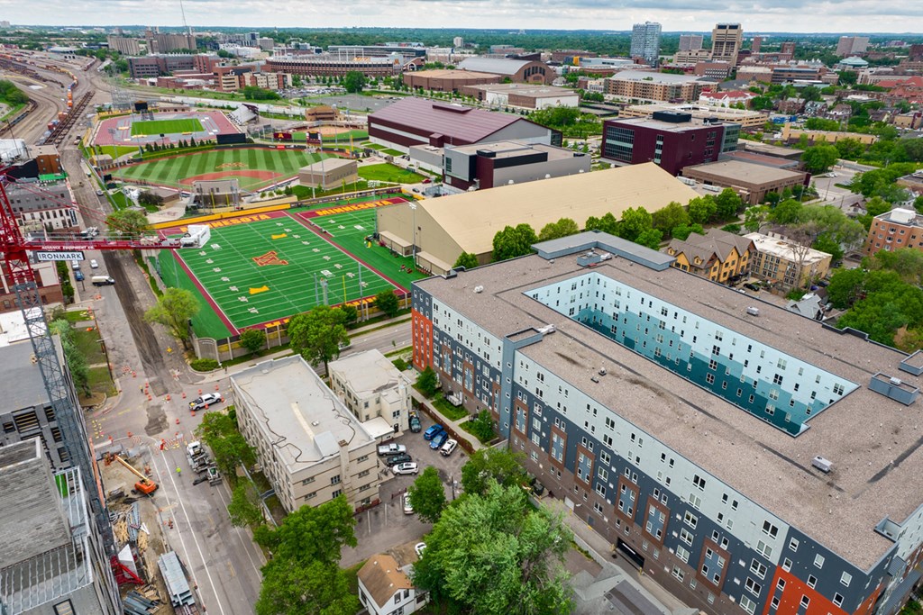 an aerial view of a city with a football field and buildings