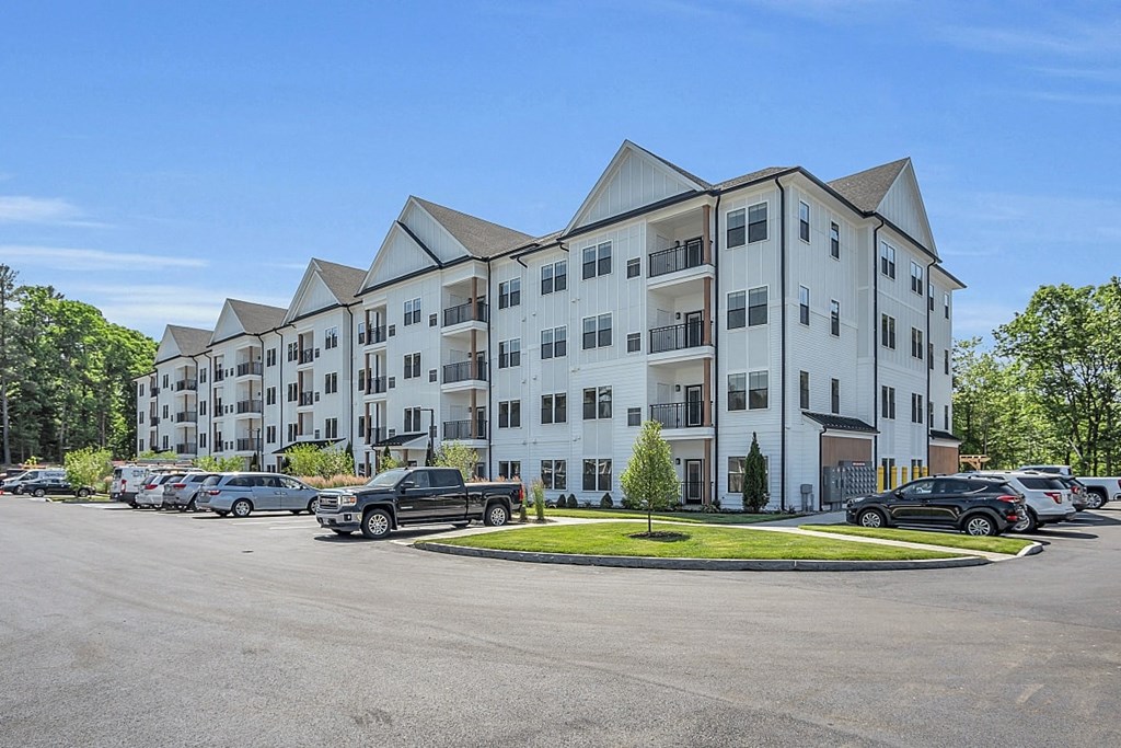 a large apartment building with cars parked in a parking lot