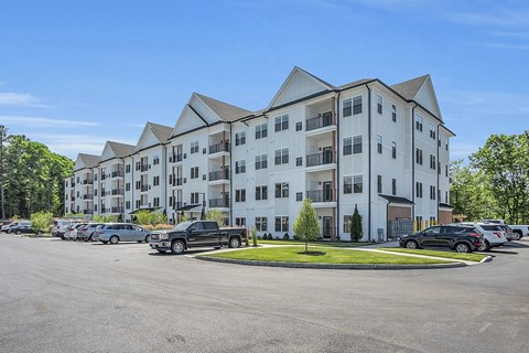 a large apartment building with cars parked in a parking lot