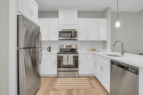 a kitchen with stainless steel appliances and white cabinets