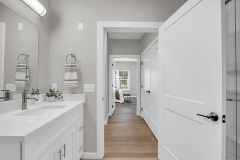 a white bathroom with white cabinets and a white sink