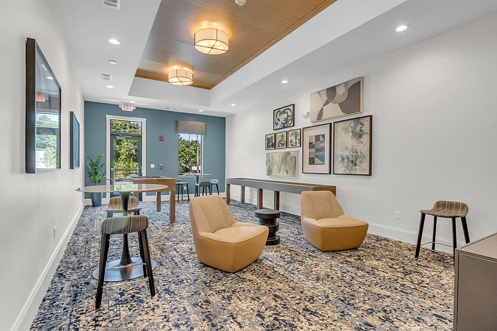 a lounge area with chairs and stools and a table