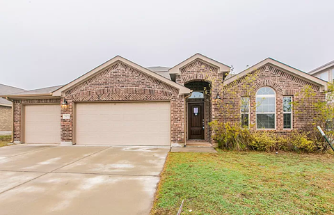 a brick house with a garage and a driveway