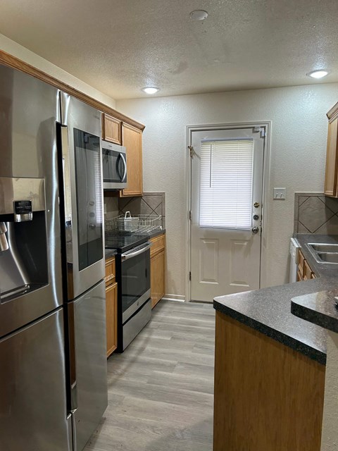 a kitchen with stainless steel appliances and wooden cabinets