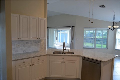 a kitchen with white cabinets and a sink