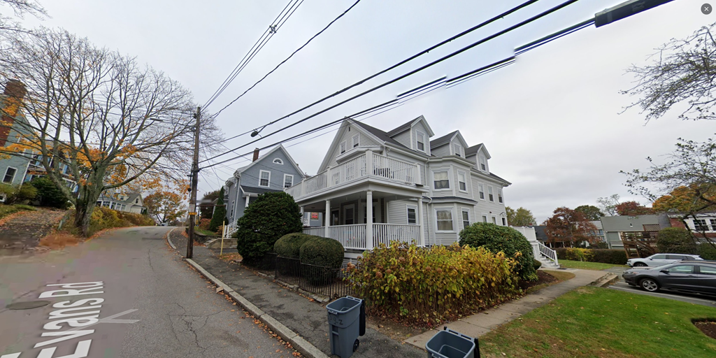 a house on the corner of a street under power lines