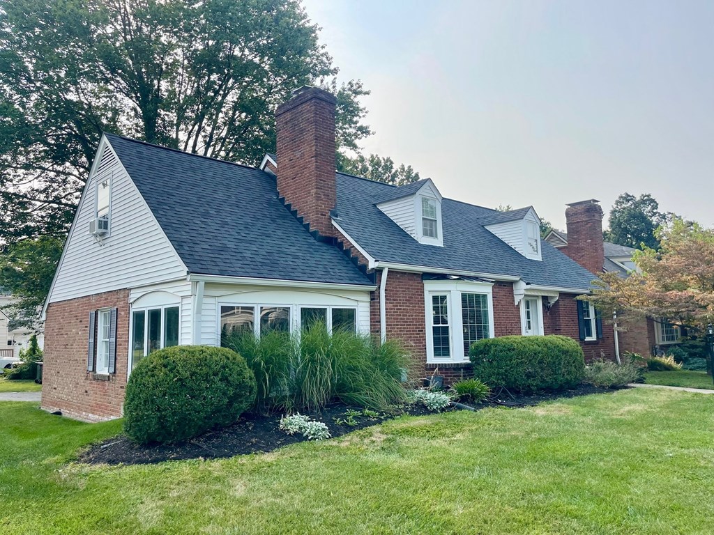 A house with a grey roof and a brick chimney.