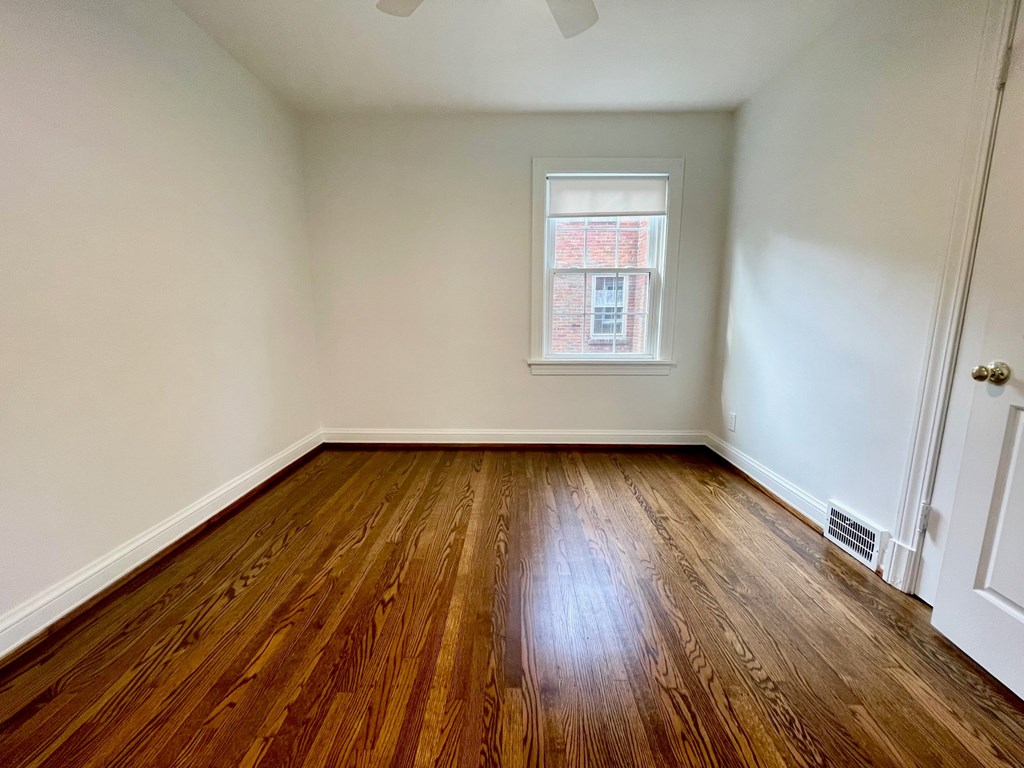 A room with wooden flooring and a window.
