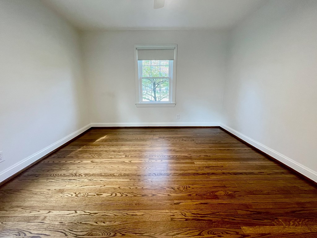 A room with wooden flooring and a window.