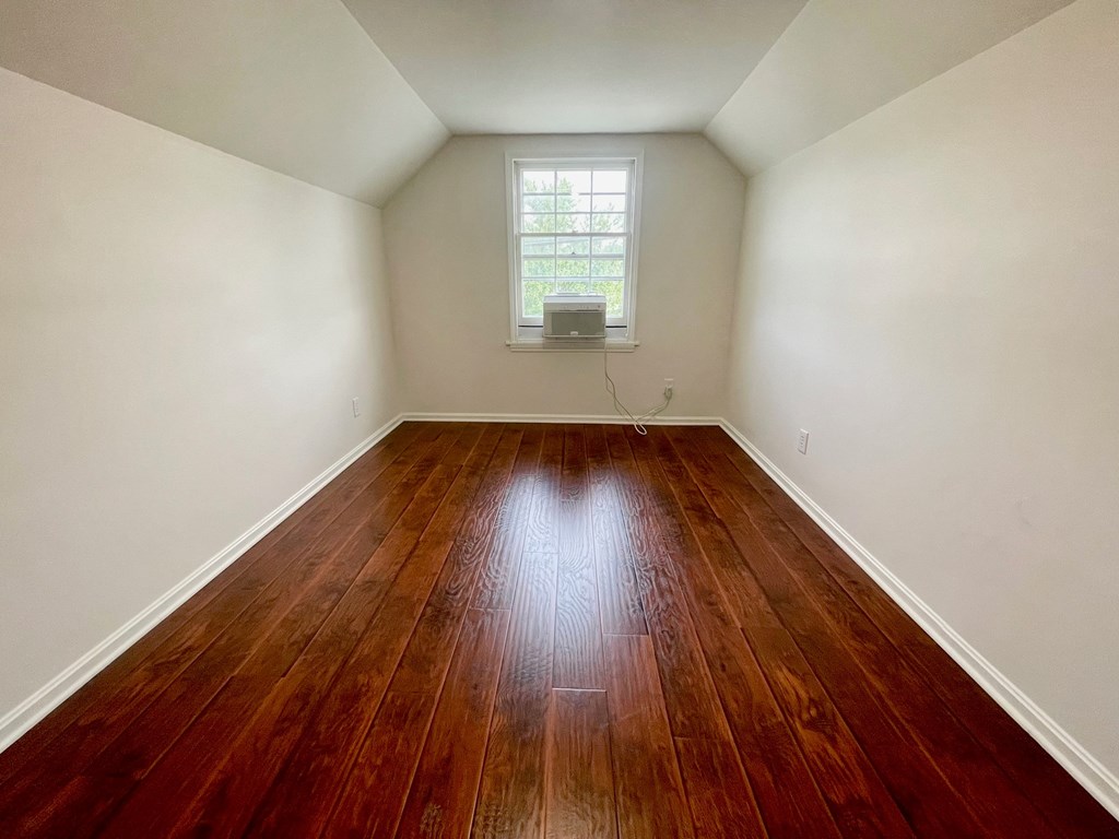 A room with wooden flooring and a window.