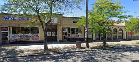 the front of a building with a bar and trees