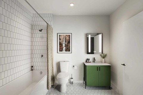 A white tiled bathroom with a green cabinet and a white toilet.