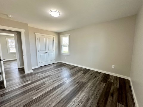 a living room with wood floors and a white door