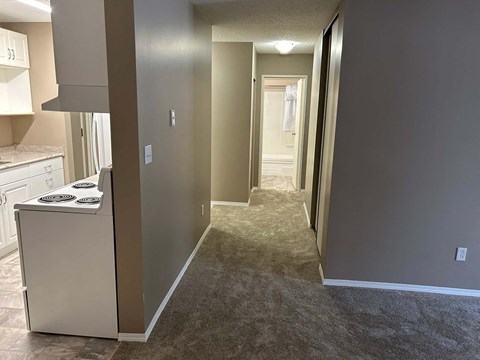 a renovated kitchen and hallway with a white stove and refrigerator