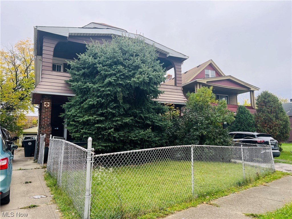 A house with a grey fence in front of it.