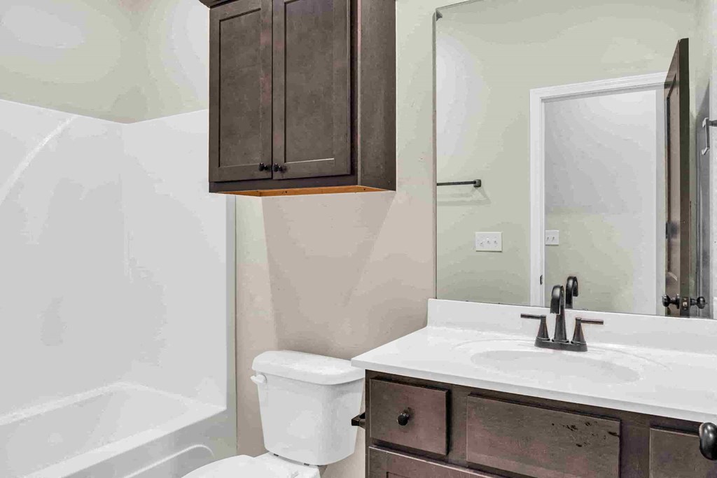 a bathroom with a sink toilet and a mirror