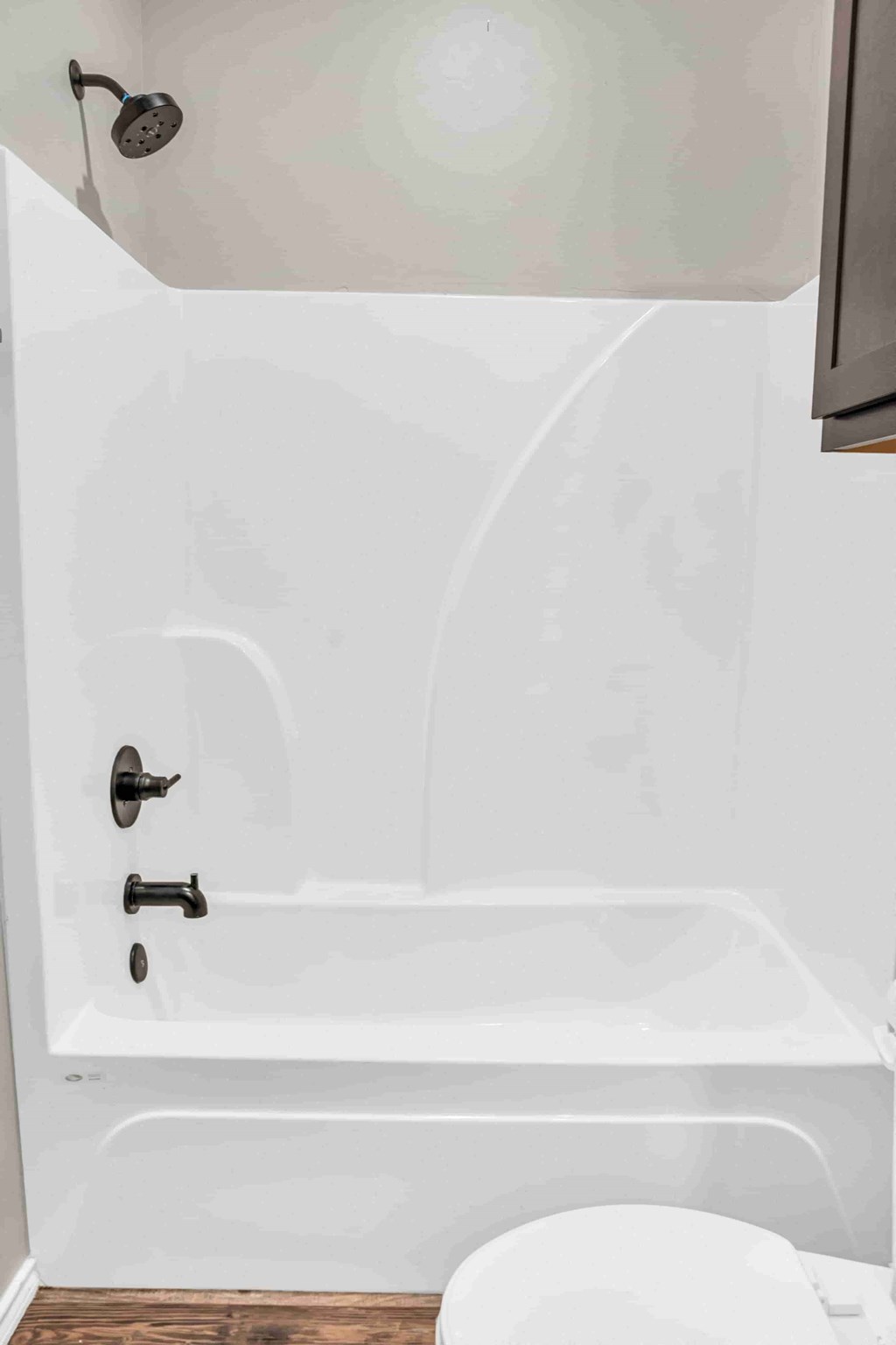 a small bathroom with a white tub and a toilet