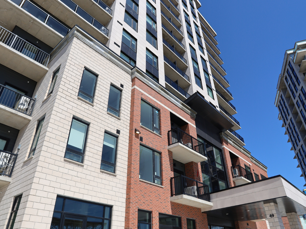 an apartment building with brick and white facade and a blue sky