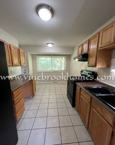 a kitchen with wooden cabinets and black appliances
