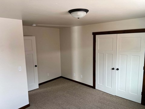a bedroom with two closets and a ceiling light
