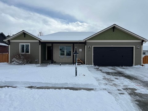 a house in the snow with a garage door