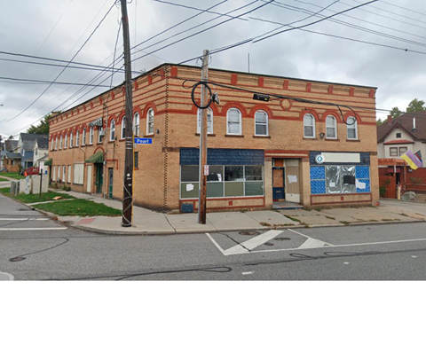 A brick building with a blue tarp on the front.