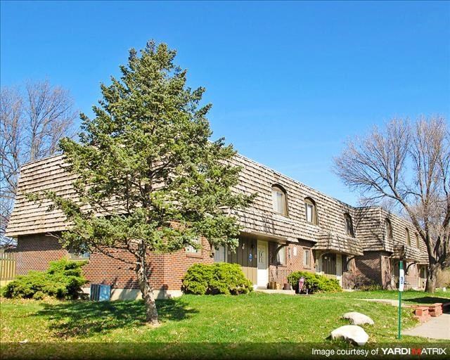 a brick house with a tree in the yard