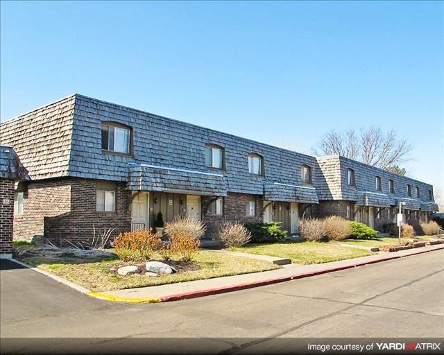 a brick house with a blue roof on a street
