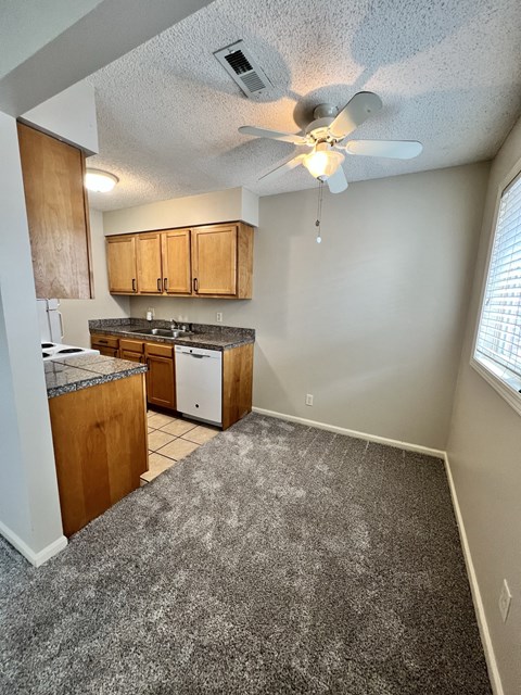an empty kitchen with a ceiling fan and