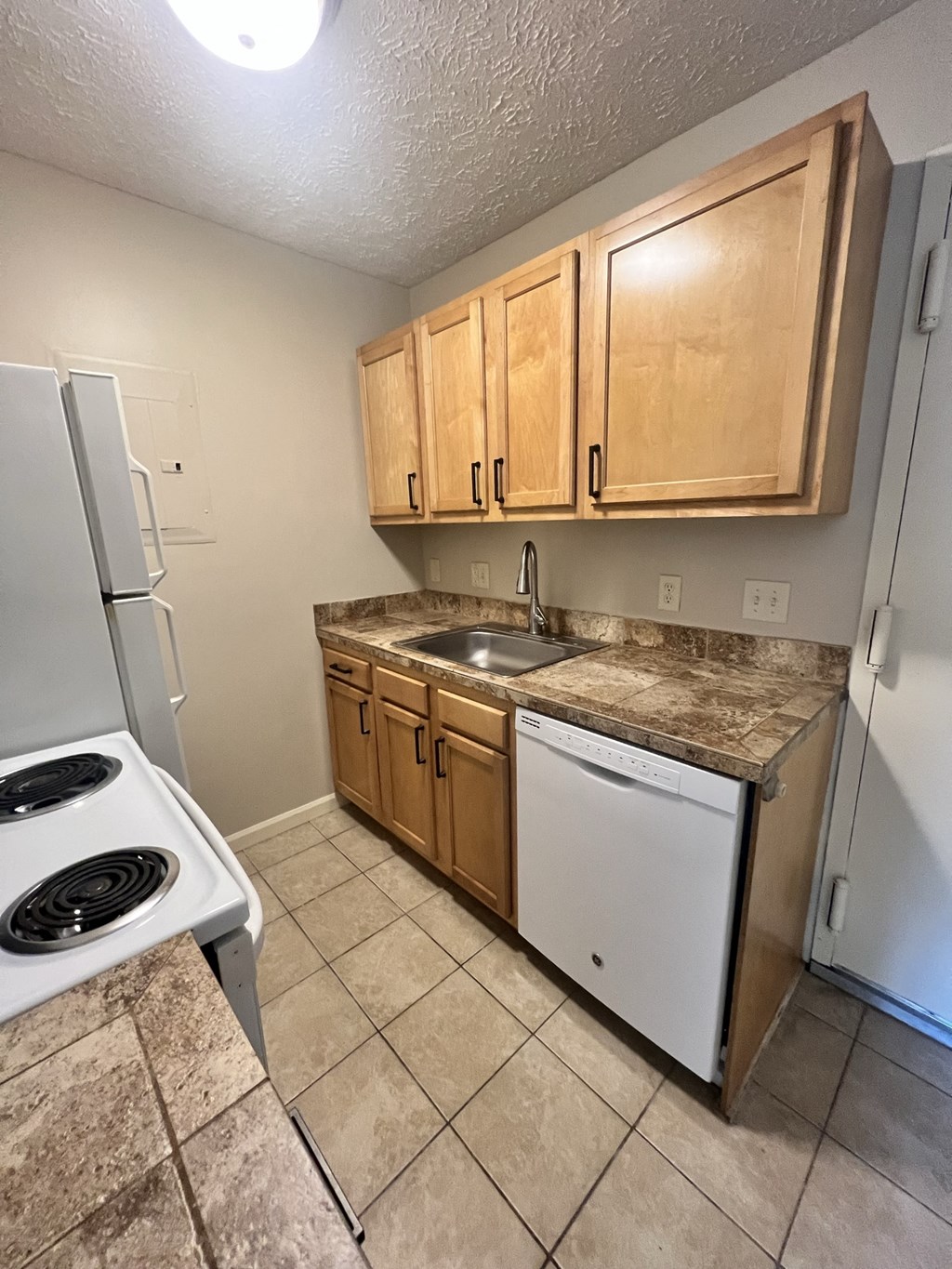 a kitchen with a stove refrigerator and sink