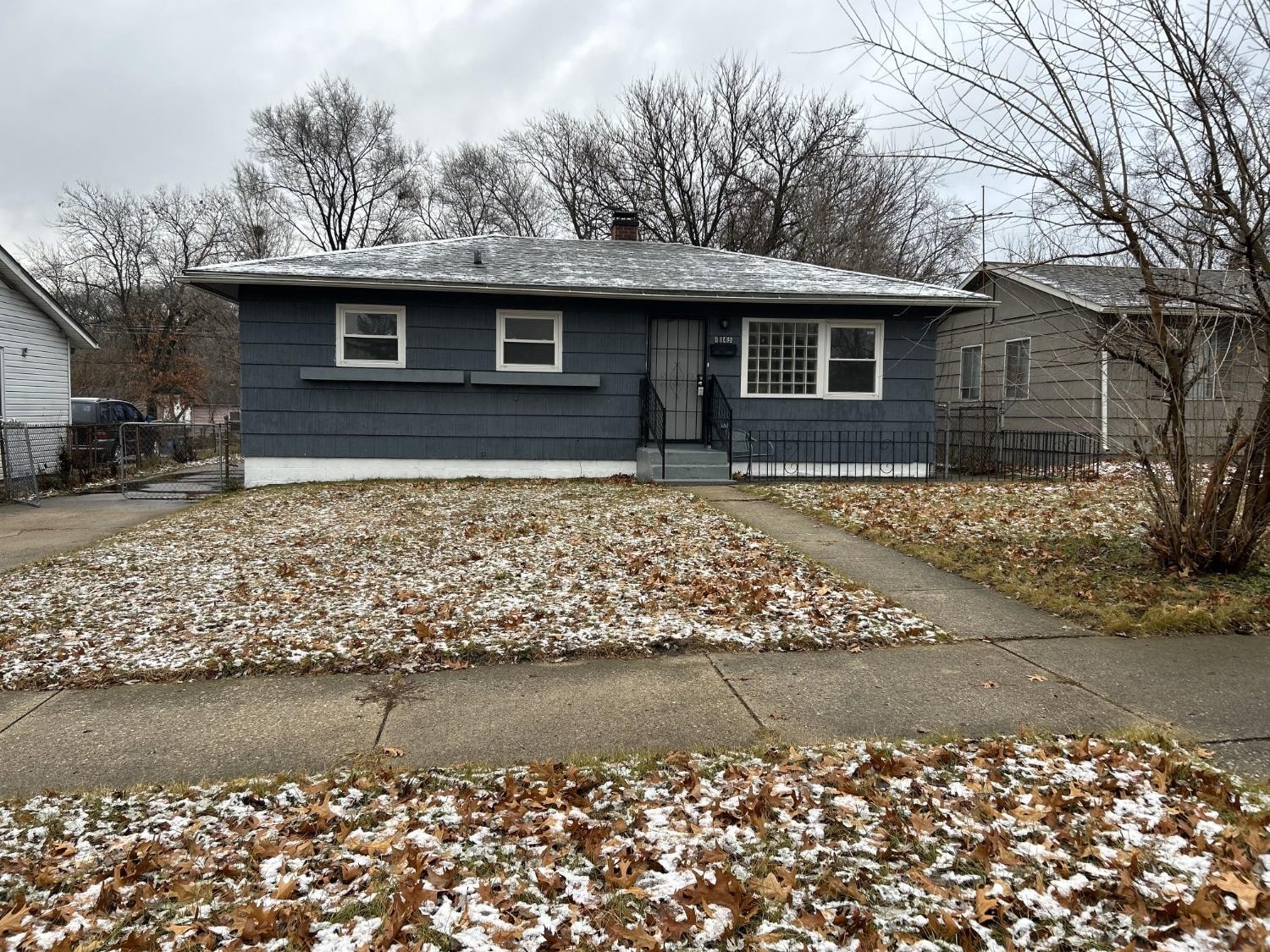 a blue house with a yard covered in snow