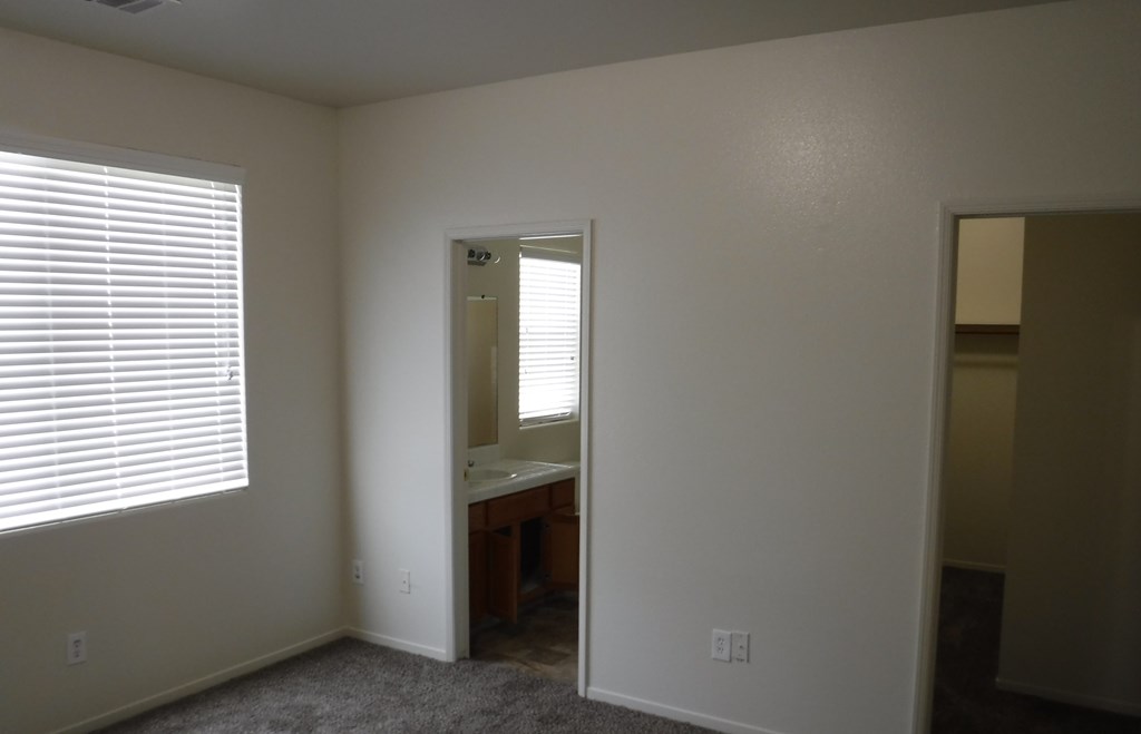a bedroom with a window and a sink and a mirror