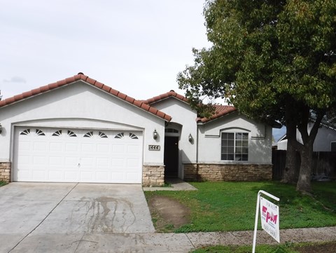 a white house with a white garage door and a driveway