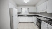 a black and white photo of a kitchen with a refrigerator