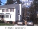 a screenshot of a house with two cars in front of it