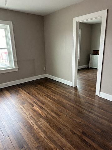 an empty living room with a wooden floor