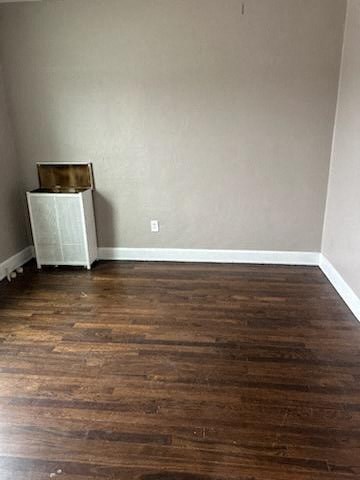 a room with wooden floors and a refrigerator