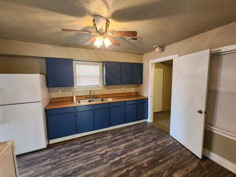 a kitchen with blue cabinets and a ceiling fan