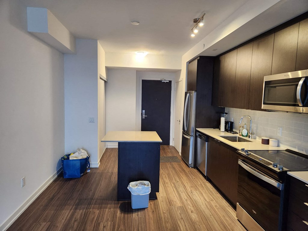a kitchen with a counter and a refrigerator and a sink