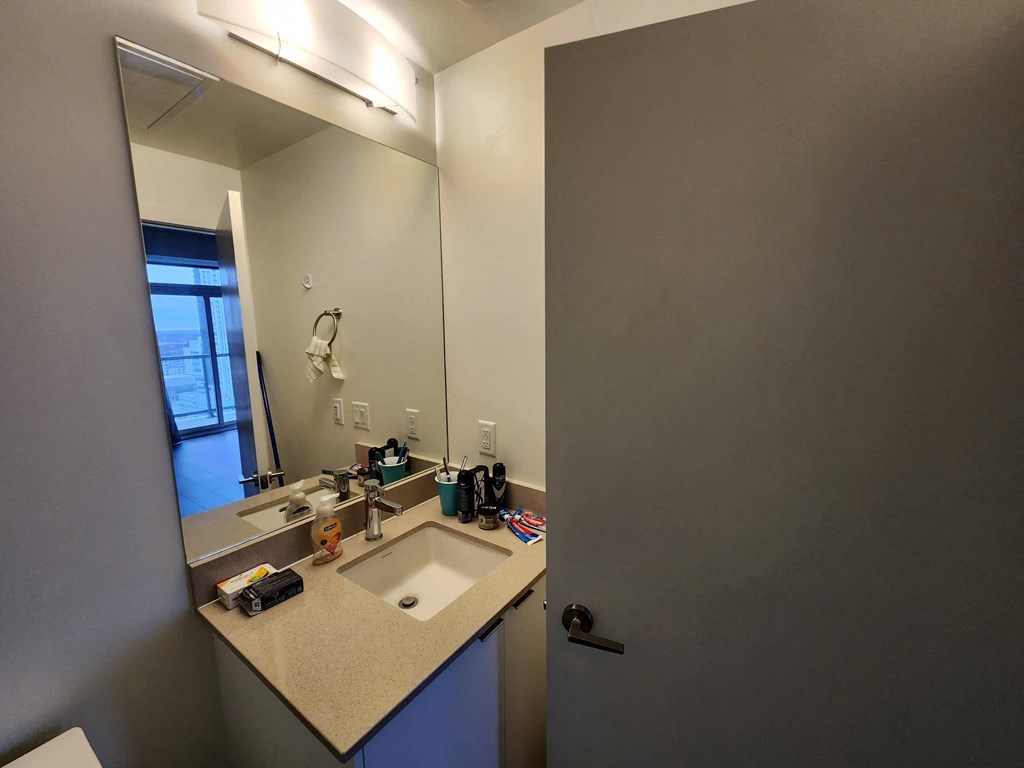 a bathroom with a sink and a mirror and a door