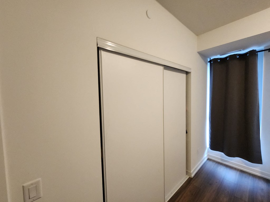 a bedroom with a closet and a window with a sliding door