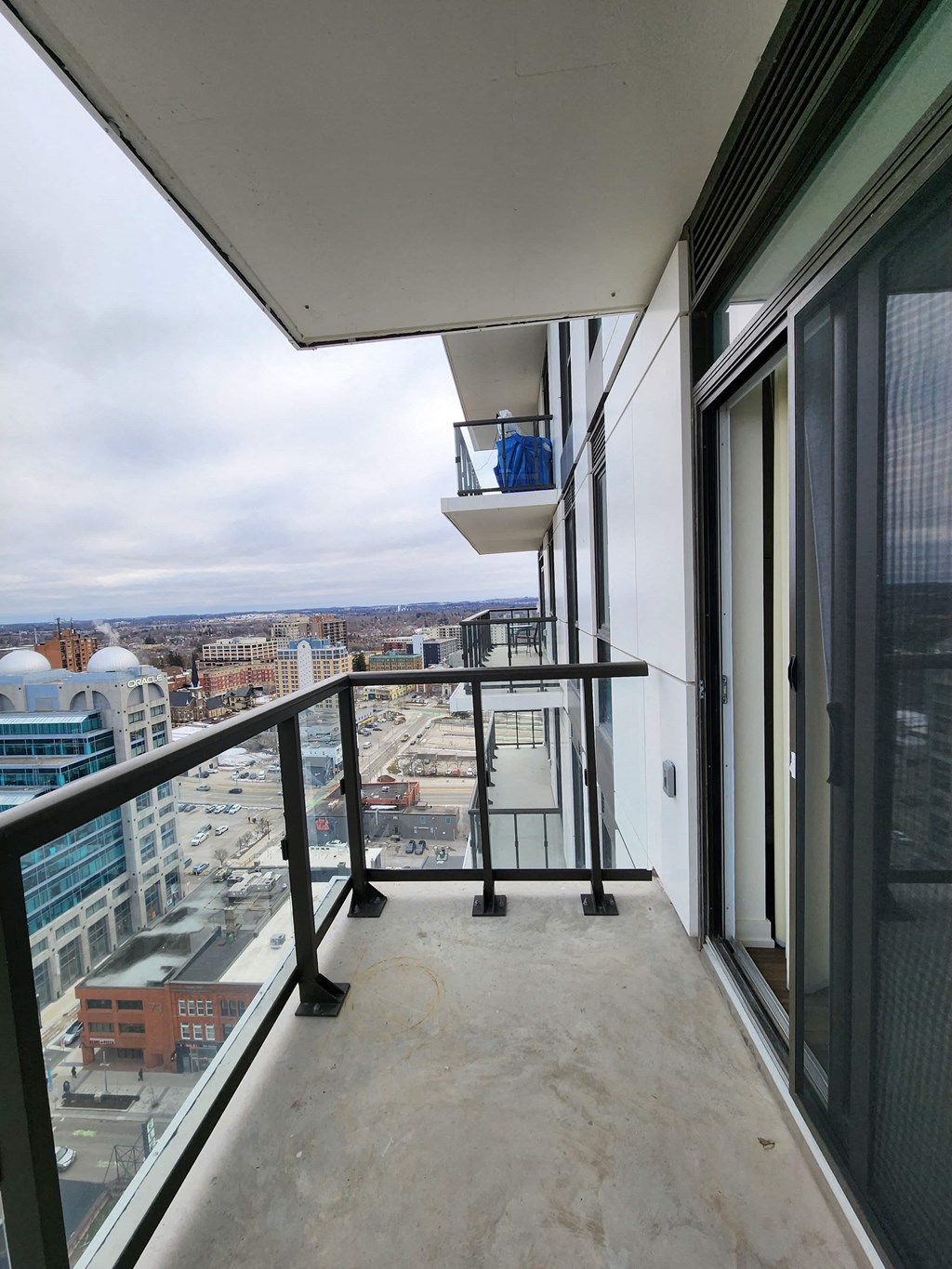 a balcony with a view of a city and a glass door