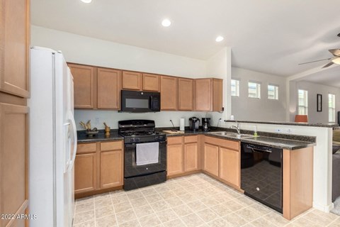 a kitchen with wooden cabinets and black appliances